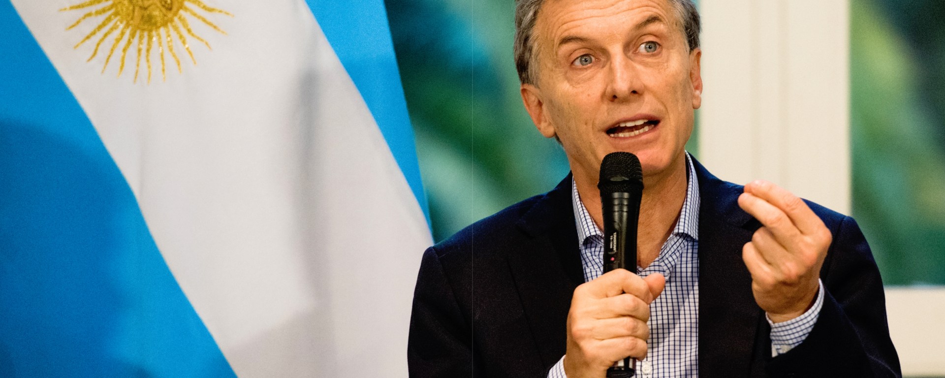 Man giving speech in front of Argentina flag
