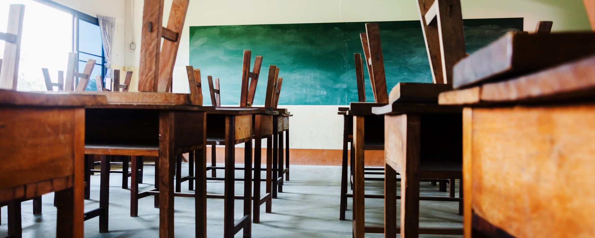 Empty classroom with chairs stacked on tables