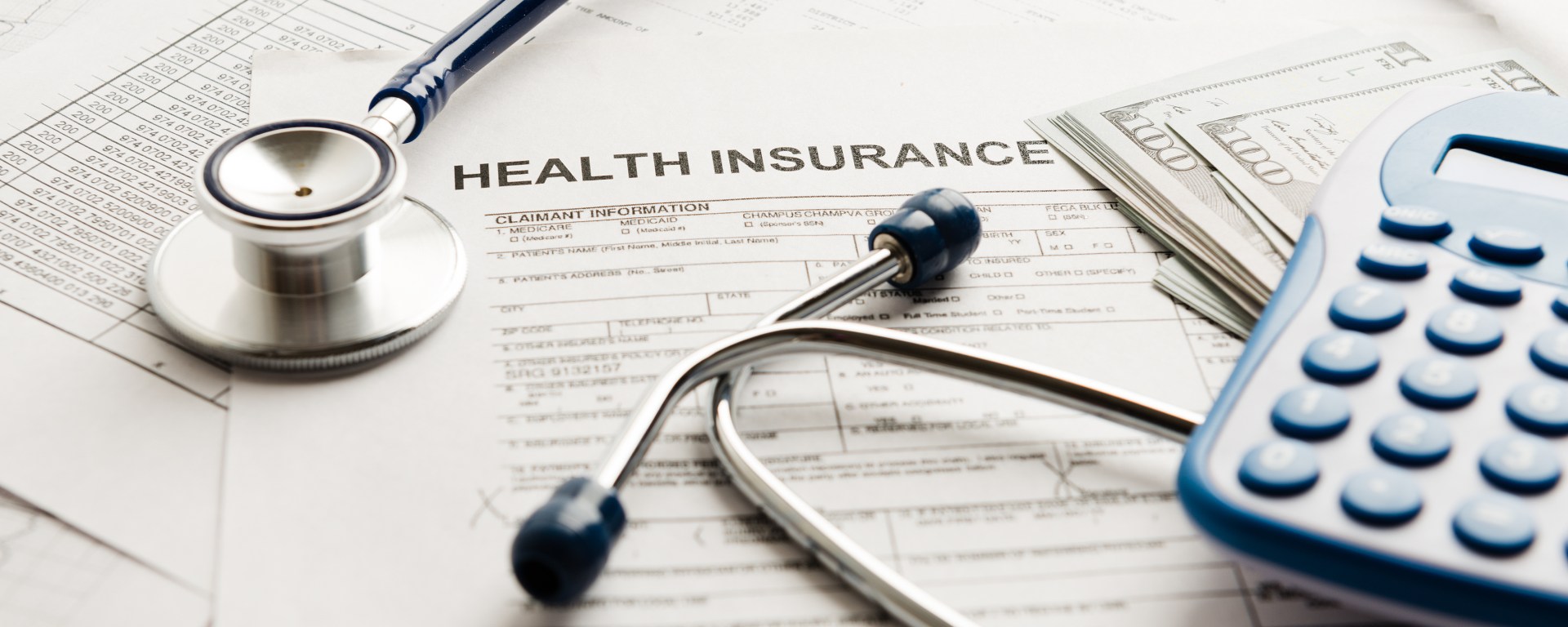 Stethoscope and calculator over a health insurance claim