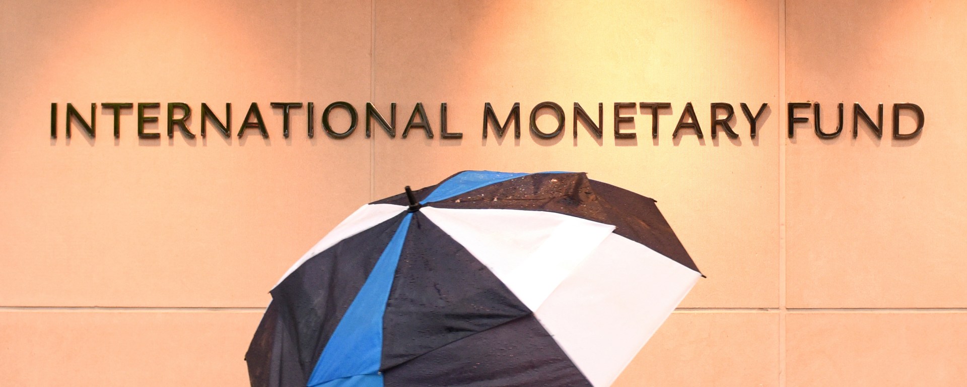 Man with Umbrella outside International Monetary Fund Building